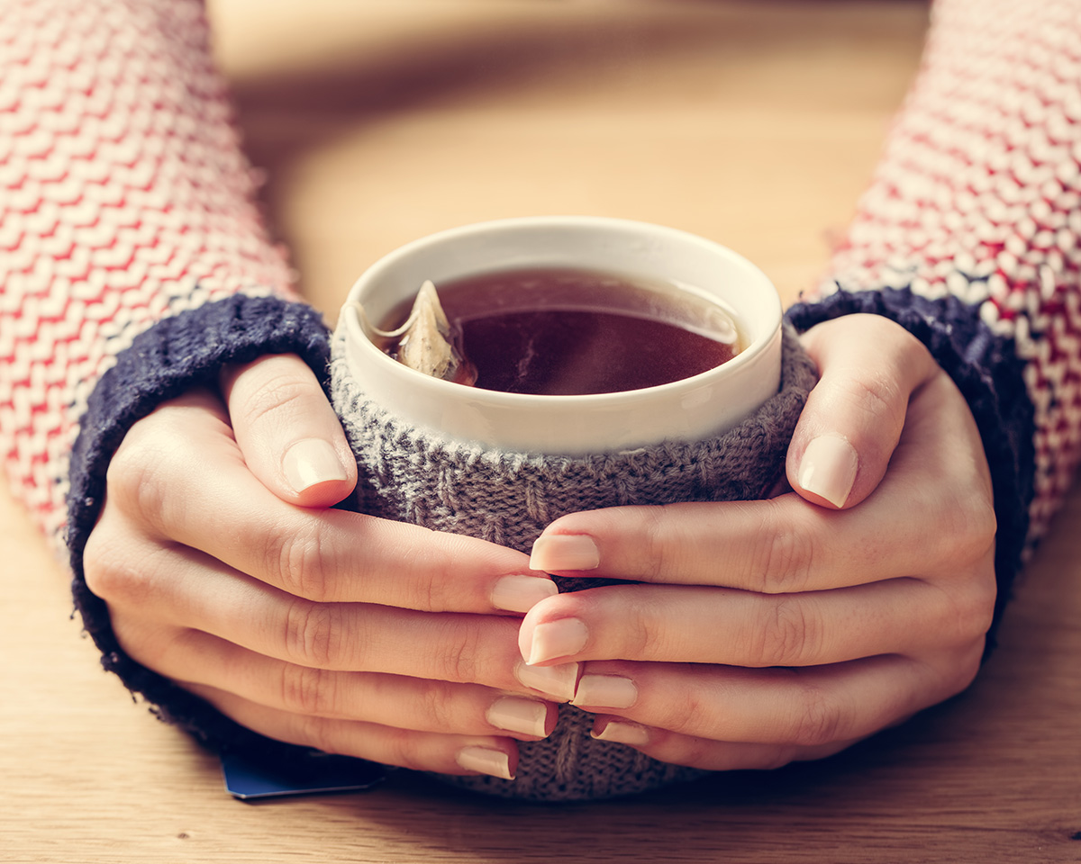 Woman holding a cup of tea.