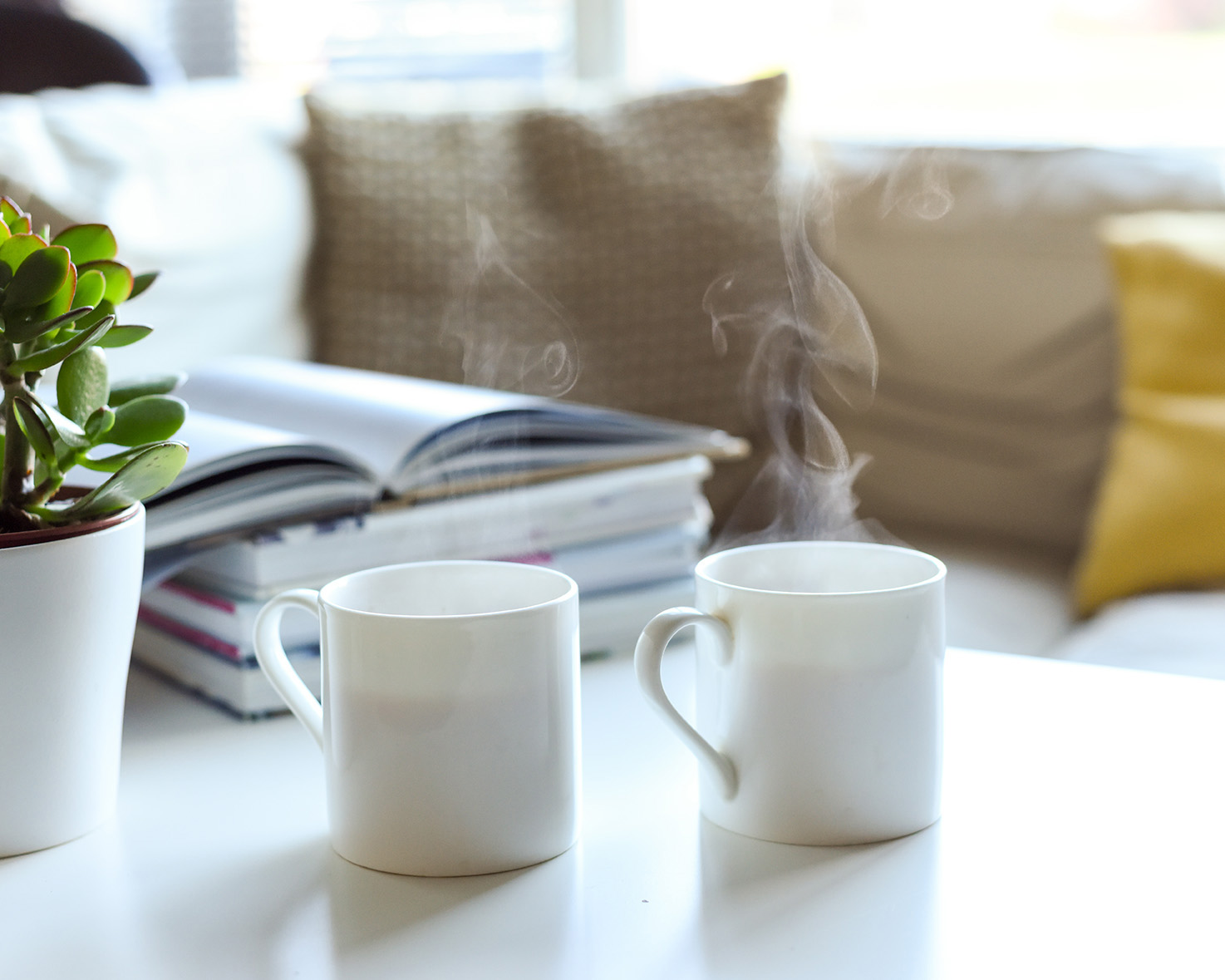 Two mugs of tea on a table with books, couch in the background. Therapy in Bel Air Maryland with Leah Brody, LCSW