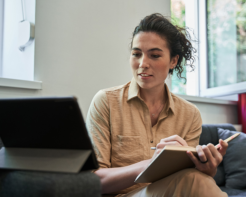 Woman at a laptop with a notebook after therapy for women